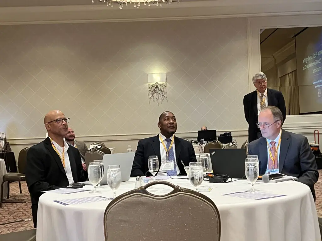A group of men sitting at tables with glasses.
